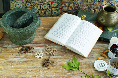 Ayurveda Medizin mit Buch Tabletten und Kräuter